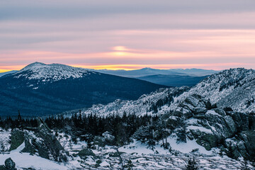 Obraz premium a beautiful pink sunset in the winter snow-capped mountains of the Urals