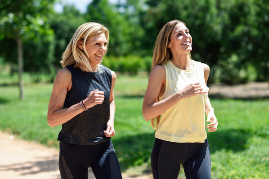 Mature woman running with her daughter in a park