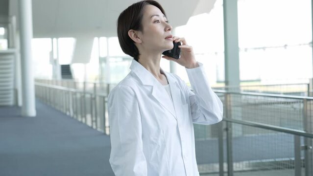 電話をする白衣を着た女性