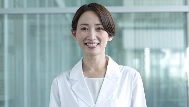 カメラ目線で微笑む白衣を着た女性