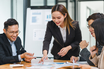 Business professionals review data during meeting in modern office.