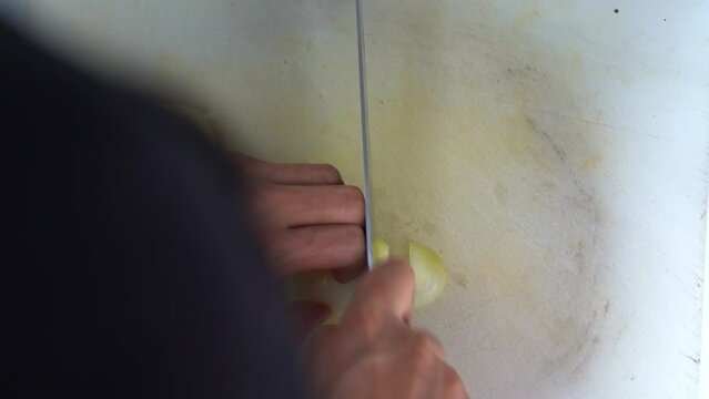 Professional kitchen hand, slicing brunoise cut the onion, preparing the ingredients for restaurant operation, close up shot.