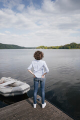 Woman standing on jetty with moored boat