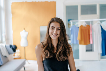 Portrait of happy young woman in fashion studio