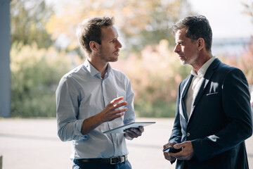 Two businessmen talking at the window