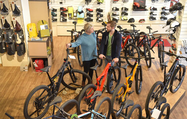 Salesperson helping customer in bicycle shop