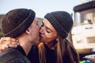 Kissing couple wearing wooly hats