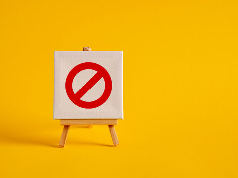 A canvas with no entry sign on an easel with yellow background with copy space.