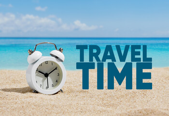 An alarm clock on the sands of a beach with the word travel time.
