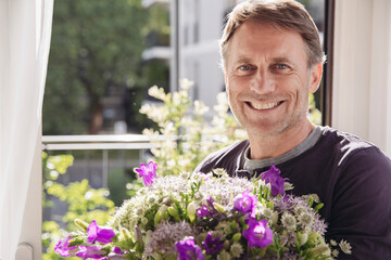 Portrait of smiling man with bunch of flowers
