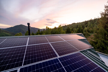 Rooftop with solar panels on house in mountains. Energy independence and sustainability concept