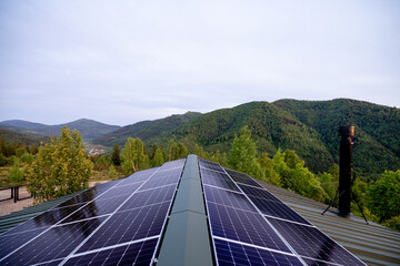 Rooftop with solar panels on house in mountains. Energy independence and sustainability concept