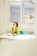 Portrait of happy freelancer sitting at desk in studio