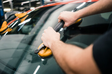 Close-up of car mechanic in a workshop changing car window