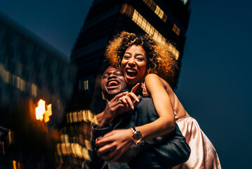Laughing young couple having fun at night in the city