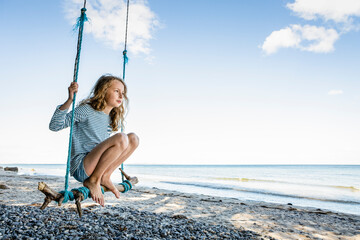 Girl on a swing at the beach