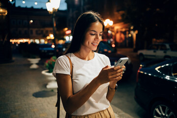 Young woman using smartphone in the city at night