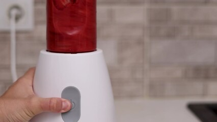 strawberry in kitchen, woman washing fruits, cutting with knife and putting in blender for smoothie or juice.thrown fruits on table.hand pouring smoothie in glass.slice half of strawberries on plate.