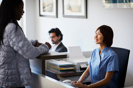 Patient at reception desk of a dental practice - Powered by Adobe