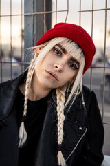 Portrait of young woman with blond braids wearing red woolly hat