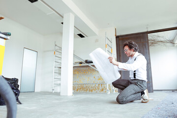 Architect with construction plan at construction site