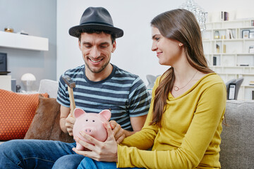 Couple in furniture store demolishing piggy bank