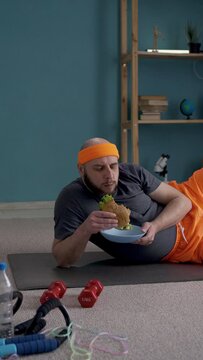 Funny man eating delicious burger. Sport, failed diet, workout exercise