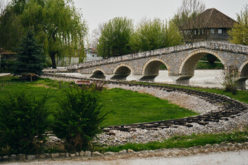 Stanisici Ethno Village in Bosnia and Herzegovina country. A stone pedestrian arch bridge and a...