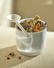 herbal tea made from large herbs in a glass with a spoon