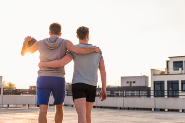 Friends playing basketball at sunset on a rooftop