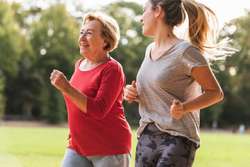 Granddaughter and grandmother having fun, jogging together in the park