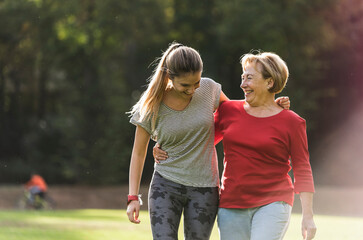 Granddaughter and grandmother having fun, jogging together in the park