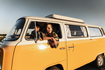 Happy couple sitting in their camper, watching the sunset