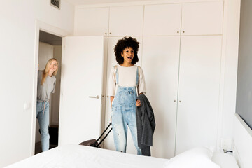 Two happy women with baggage arriving in accomodation