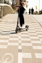 Man using E-Scooter and mobile phone in the city, partial view