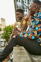 Friends sitting on roof terrace in the city drinking beer, Maputo, Mozambique