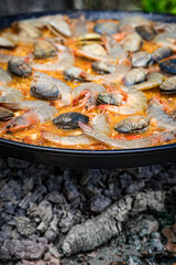 paella de arroz valenciana de marisco a la brasa de una barbacoa