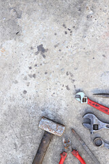 Old working tools on a concrete surface, top view. Hammer, side cutters, flat file, adjustable wrench and wrench. Hand tool. Builder's Day or Father's Day. Construction and renovation concept