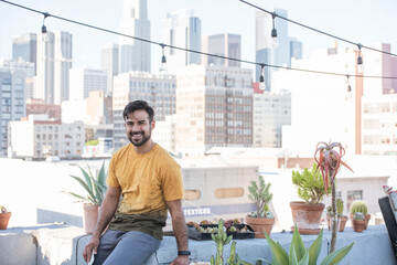 Young man sitting on rooftop terrace