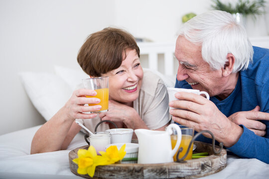 Senior couple having breakfast in bed
