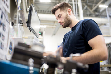 Man working in a modern factory operating a machine
