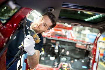 Man working at bodywork in modern car factory