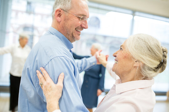 Group of active senior attending dance course in retirement home