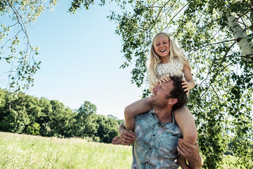 Happy father carrying daughter piggyback