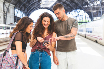 Friends with cell phone on train station platform