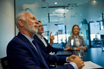 Portrait of senior businessman listening in a meeting