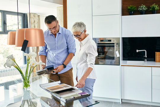 Man and mature woman in a kitchen retail store examining material samples