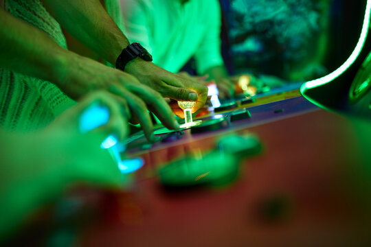 Close-up of friends playing in an amusement arcade