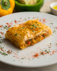 Puff pastry empanada filled with vegetables and squid.
