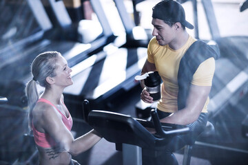 Young man and woman talking in gym